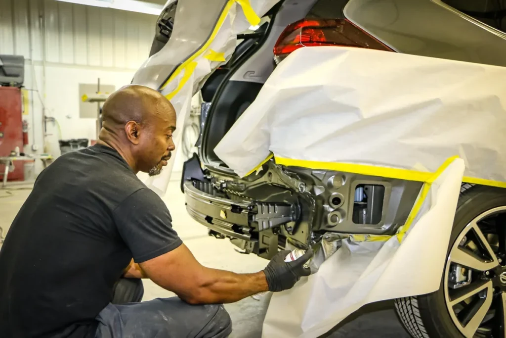 Technician repairing the rear bumper of a car